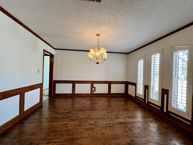 empty room with a wainscoted wall, ornamental molding, dark wood-style flooring, and a chandelier