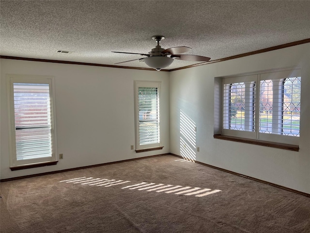 unfurnished room with a textured ceiling, carpet, visible vents, and crown molding