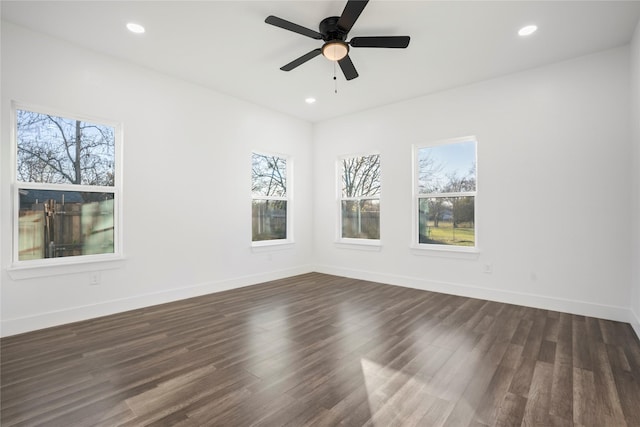 empty room with dark hardwood / wood-style flooring, ceiling fan, and a healthy amount of sunlight