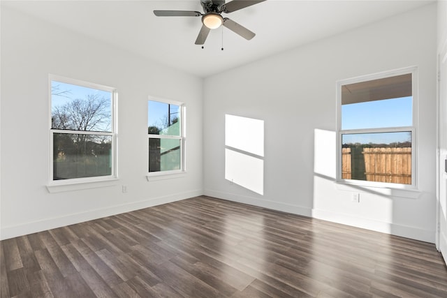 spare room with a wealth of natural light, ceiling fan, and dark hardwood / wood-style floors