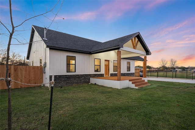 view of front facade with a lawn and a deck