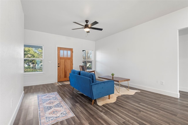 living room featuring dark wood-type flooring and ceiling fan