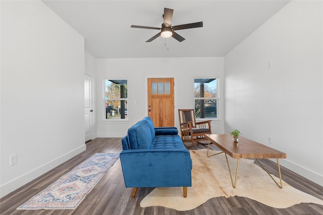 living room with ceiling fan and dark wood-type flooring