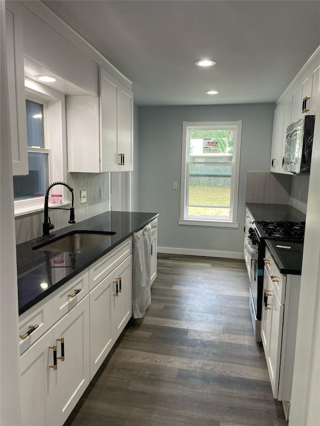 kitchen with sink, white cabinetry, stainless steel appliances, and dark wood-type flooring