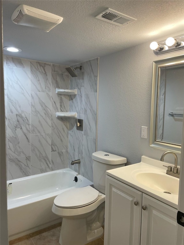 full bathroom featuring a textured ceiling, vanity, tiled shower / bath combo, and toilet