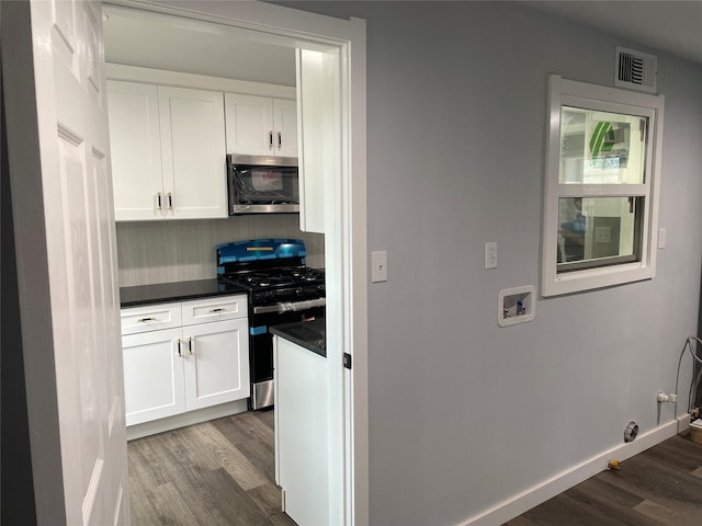 kitchen featuring white cabinets, stainless steel appliances, and dark wood-type flooring