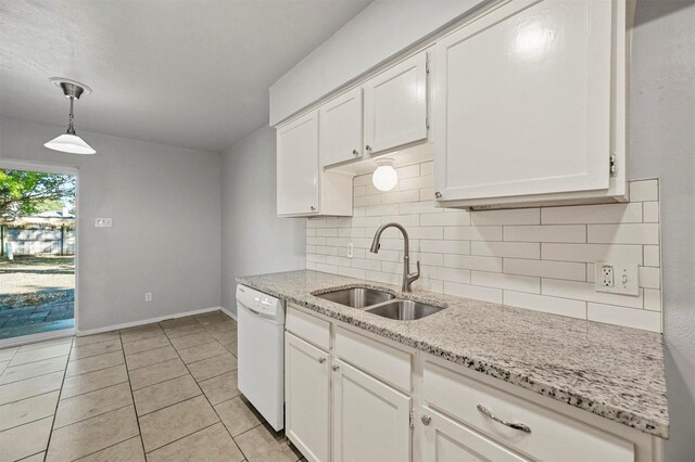 kitchen featuring white dishwasher, white cabinets, sink, hanging light fixtures, and tasteful backsplash