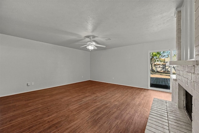 unfurnished living room with a fireplace, wood-type flooring, a textured ceiling, and ceiling fan