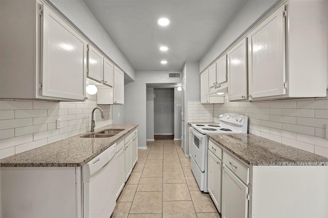 kitchen with dark stone countertops, sink, white cabinets, and white appliances