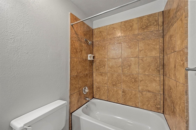 bathroom featuring tiled shower / bath and toilet