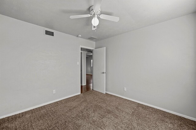 unfurnished bedroom featuring ceiling fan and dark carpet