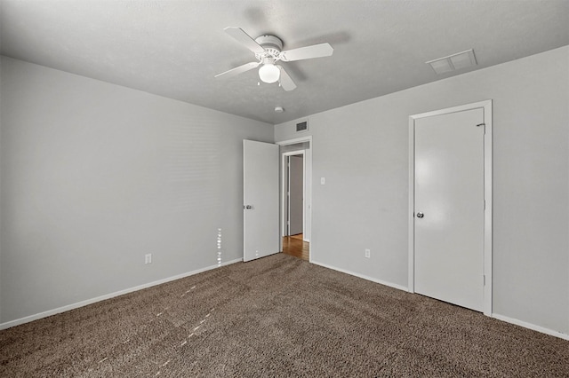 unfurnished bedroom featuring carpet flooring, a textured ceiling, a closet, and ceiling fan