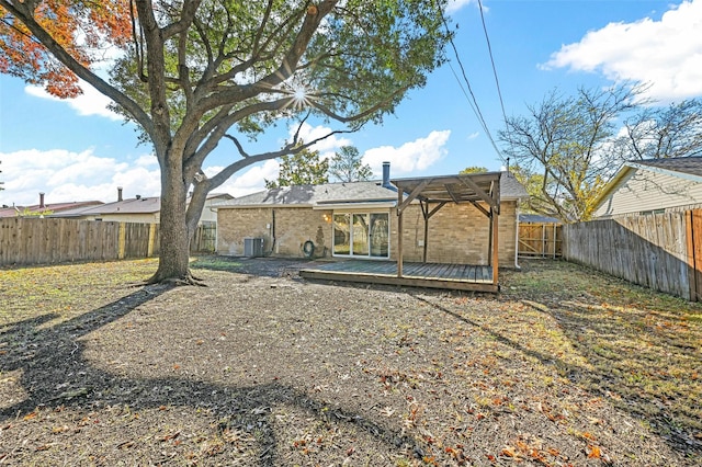 rear view of property featuring a wooden deck and central AC