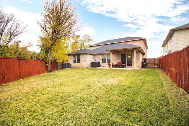 back of house featuring a patio, a lawn, and central air condition unit