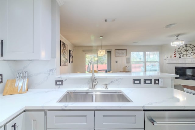 kitchen with sink, plenty of natural light, stainless steel dishwasher, and white cabinets