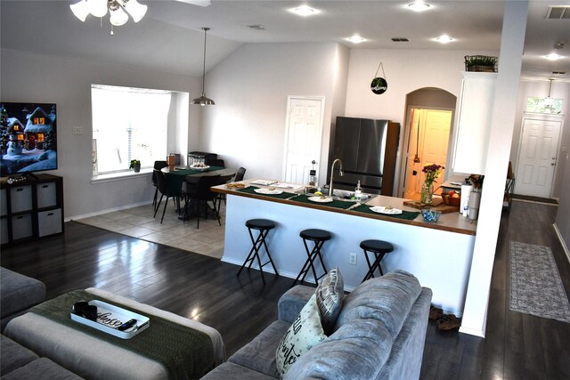 living room featuring dark hardwood / wood-style floors, a premium fireplace, and vaulted ceiling