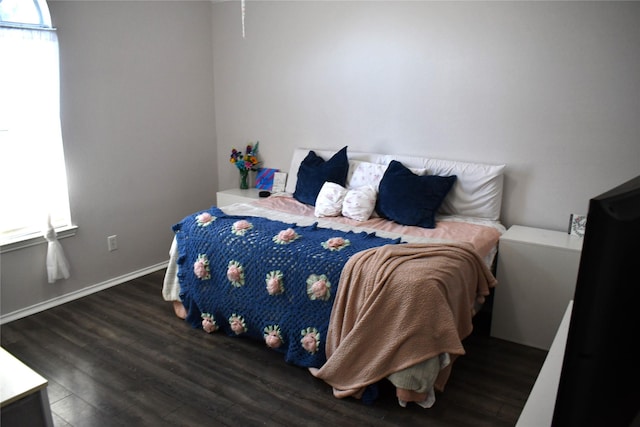 bedroom with dark hardwood / wood-style flooring