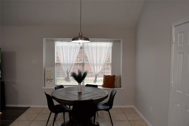 tiled dining space with lofted ceiling