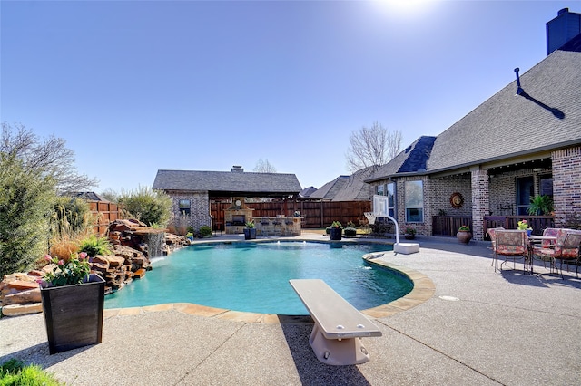 view of pool with outdoor dry bar, a fenced in pool, a fenced backyard, and a diving board