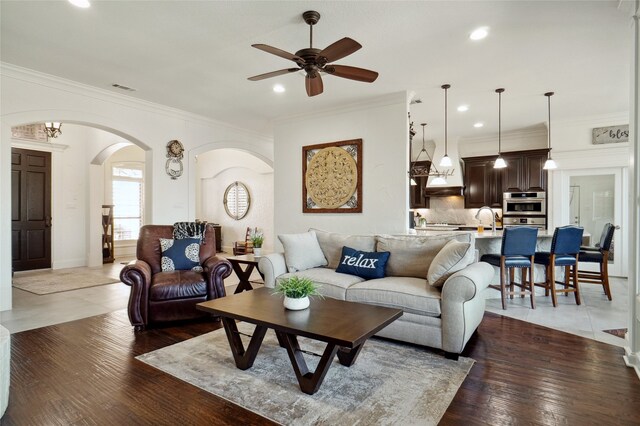 kitchen featuring kitchen peninsula, appliances with stainless steel finishes, dark brown cabinets, ceiling fan, and decorative light fixtures