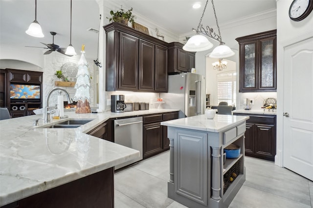 kitchen with dark brown cabinetry, sink, a center island with sink, appliances with stainless steel finishes, and pendant lighting