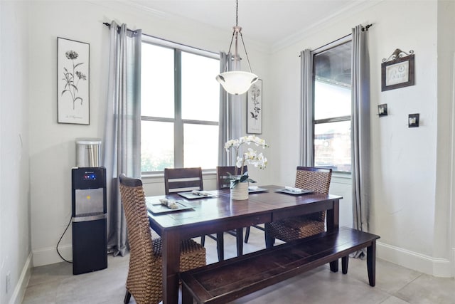 tiled dining space with crown molding and a wealth of natural light