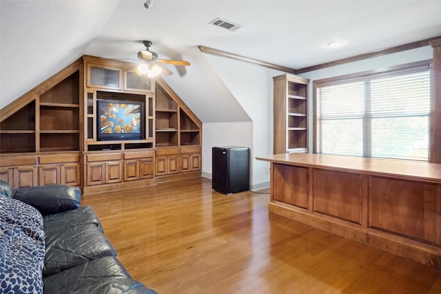 unfurnished living room with ornamental molding, lofted ceiling, built in features, and light hardwood / wood-style flooring