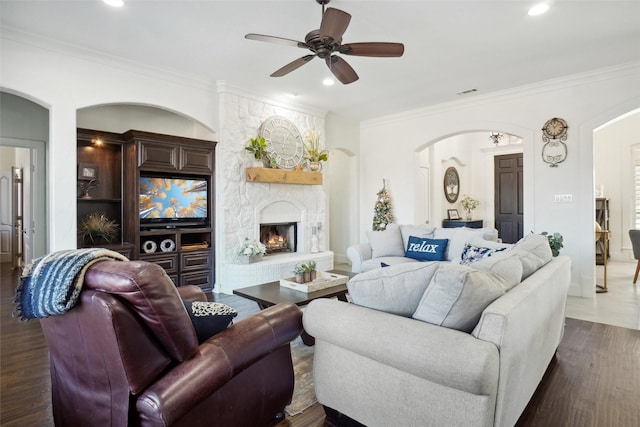 living room with a fireplace, ceiling fan, dark hardwood / wood-style flooring, and crown molding