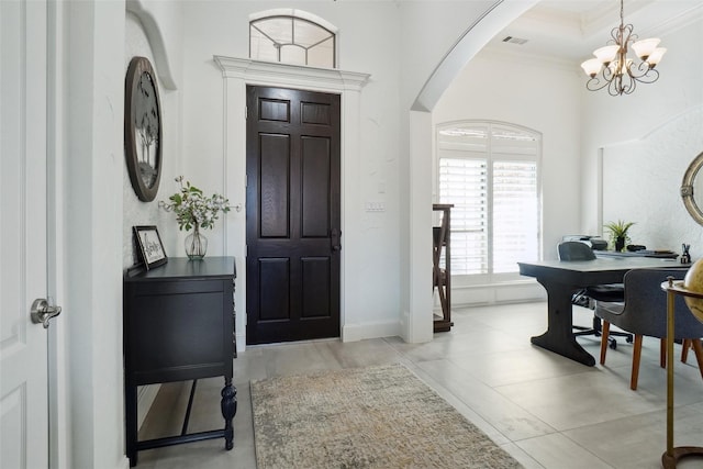 foyer entrance featuring a chandelier and crown molding