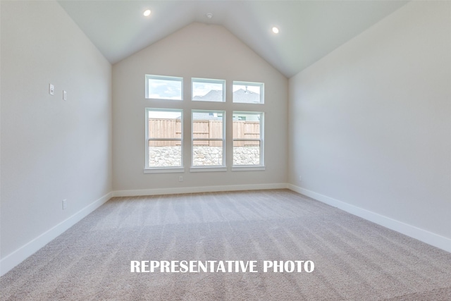 unfurnished room with light carpet and high vaulted ceiling