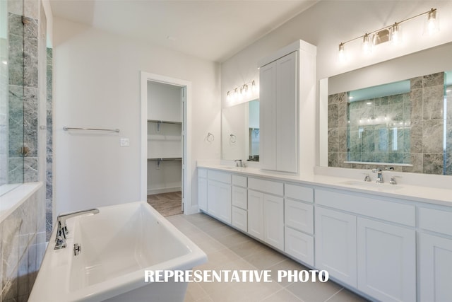 bathroom featuring vanity, tile patterned flooring, and a relaxing tiled tub