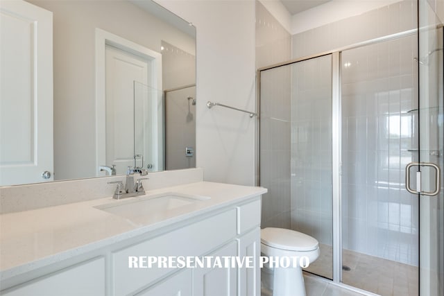 bathroom featuring vanity, an enclosed shower, and toilet