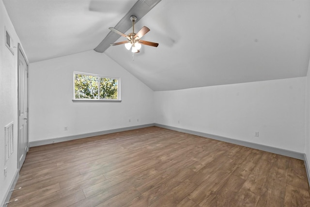 additional living space with wood-type flooring, lofted ceiling with beams, and ceiling fan