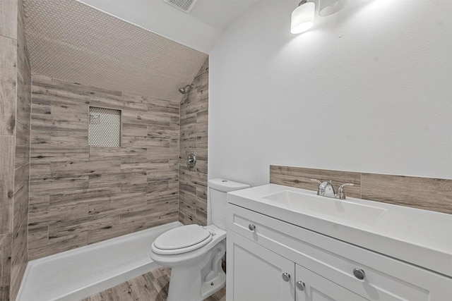 bathroom with a shower, vanity, hardwood / wood-style flooring, and lofted ceiling