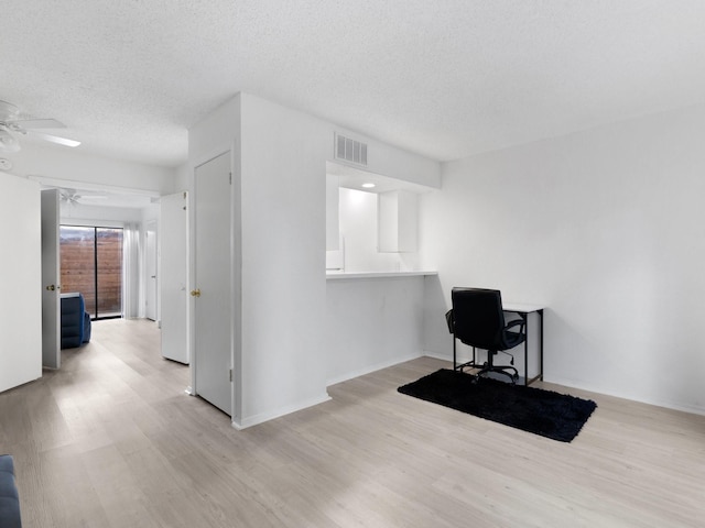 office space with a textured ceiling, light hardwood / wood-style flooring, and ceiling fan