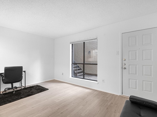 home office featuring a textured ceiling and light wood-type flooring