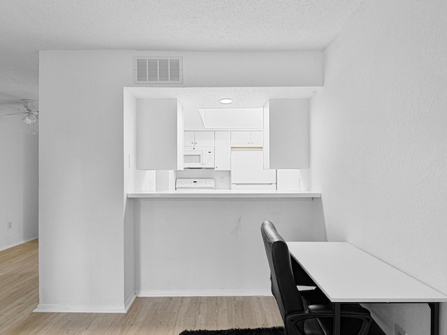 office area featuring a textured ceiling, light hardwood / wood-style flooring, and ceiling fan