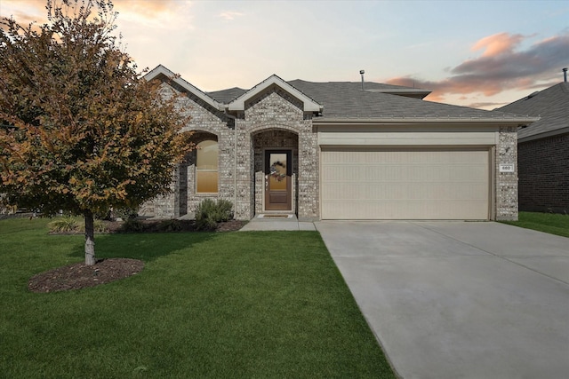 view of front of property featuring a yard and a garage