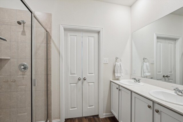 bathroom featuring hardwood / wood-style flooring, vanity, and walk in shower