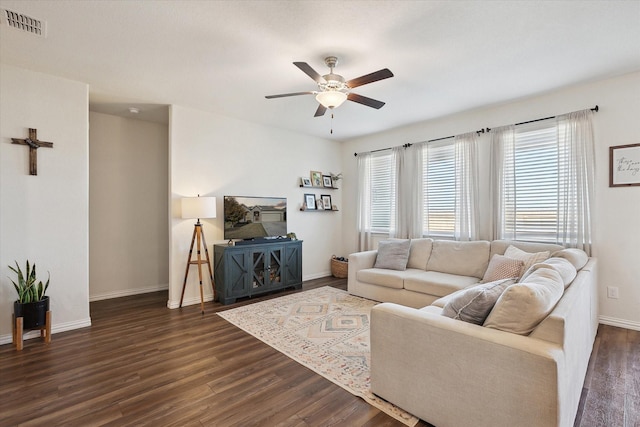 living room with dark hardwood / wood-style flooring, ceiling fan, and a healthy amount of sunlight