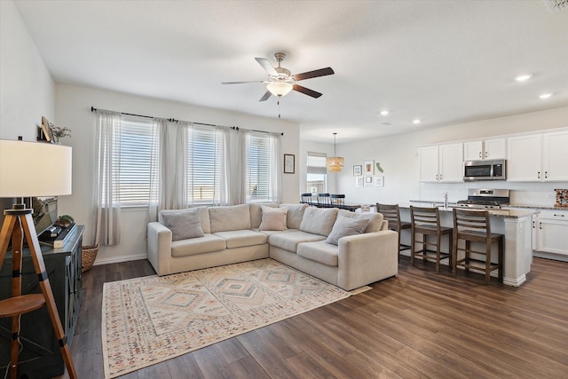 living room with ceiling fan and dark wood-type flooring