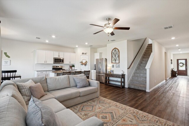 living room with ceiling fan and dark wood-type flooring