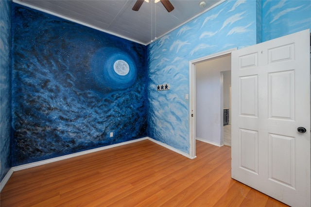 empty room with hardwood / wood-style floors and ceiling fan