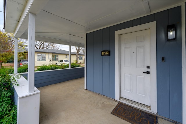 view of exterior entry featuring covered porch