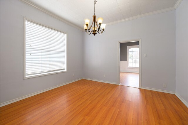 unfurnished room featuring a notable chandelier, light hardwood / wood-style floors, and crown molding