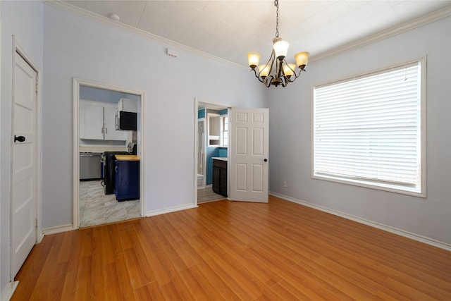 empty room with light hardwood / wood-style flooring, a chandelier, and ornamental molding