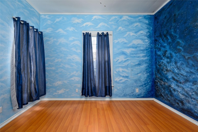 unfurnished room featuring wood-type flooring and ornamental molding