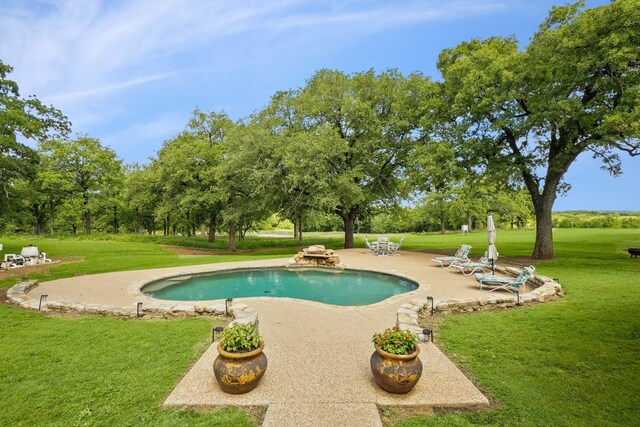 outdoor pool with a lawn and a patio area