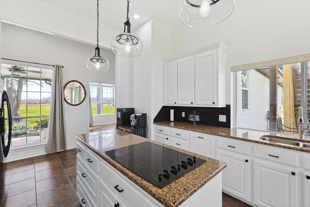 kitchen with ceiling fan, a center island, white cabinets, backsplash, and black appliances