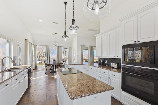 kitchen featuring visible vents, a sink, black appliances, white cabinetry, and backsplash